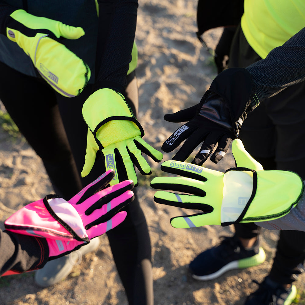 Hands wearing bright yellow, pink and black reflective gloves. colored reflective gloves